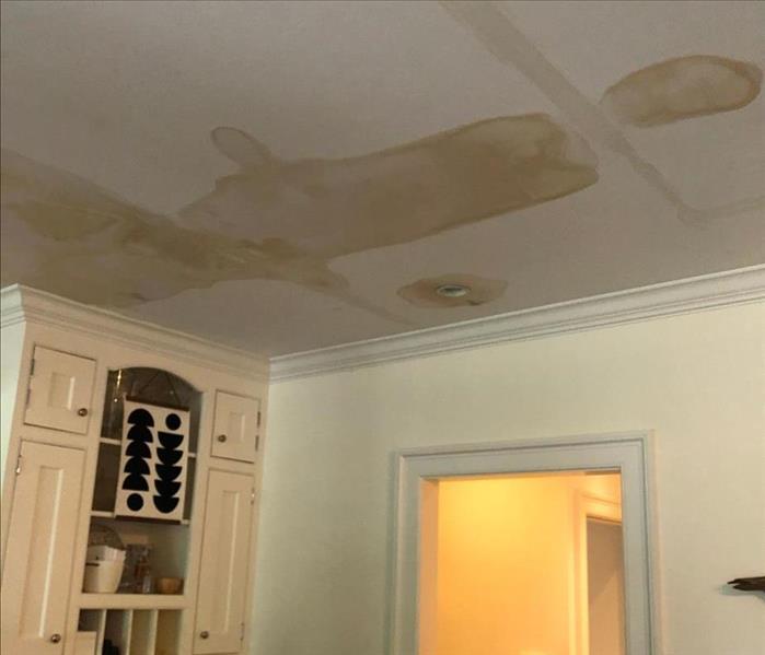 brown discoloration on kitchen ceiling due to a water leak, creating water damage