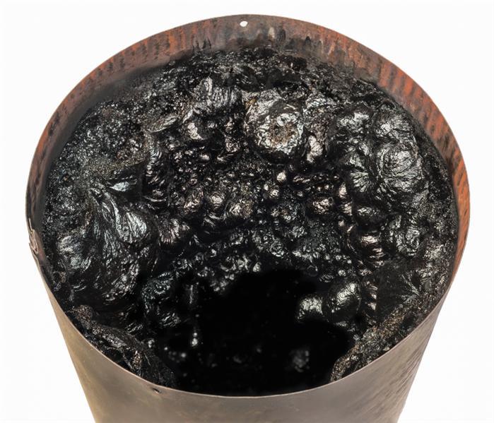 image of creosote buildup in chimney. black, bubbly, and tar like