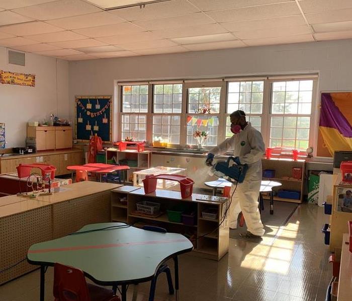 image of SERVPRO employee in full PPE fogging a classroom for coronavirus